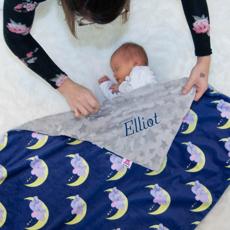 Baby boy with a personalized blanket showing elephants sleeping on moons