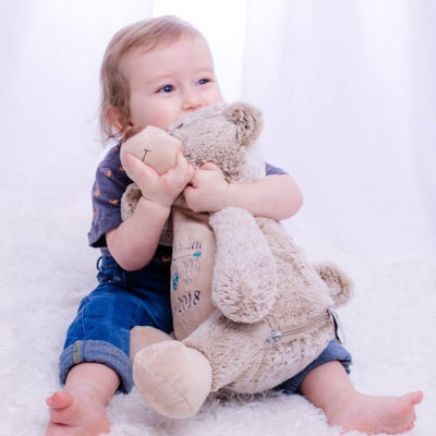 Boy hugging his personalized teddy bear with name